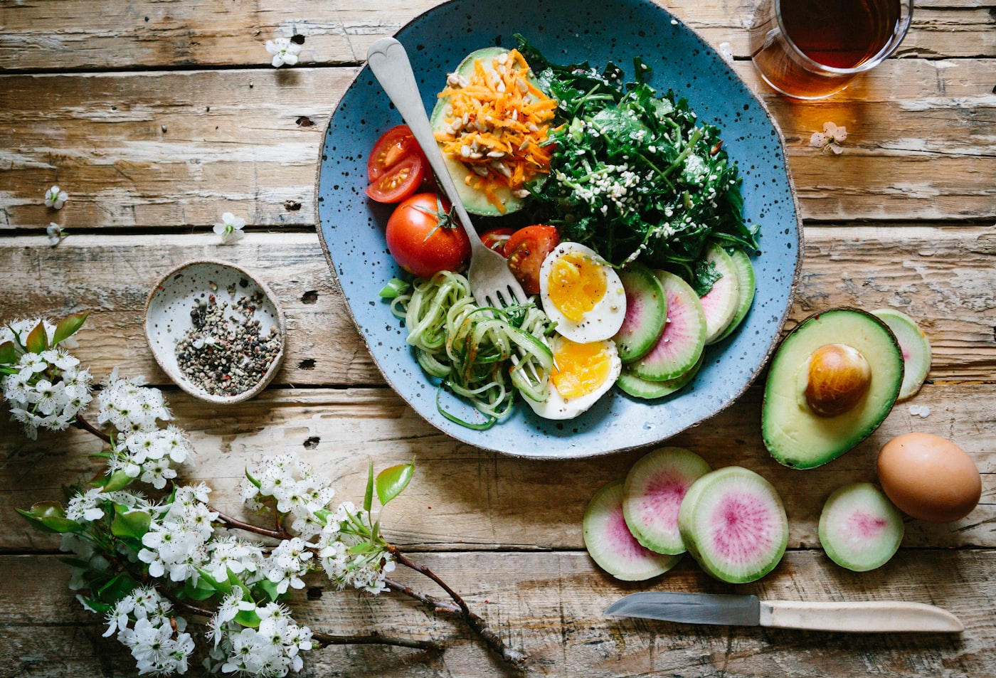Balanced bowl with greens, egg, avocado and fresh vegetables